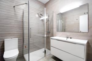 a bathroom with a toilet and a sink and a shower at Piso con Encanto in Cádiz +18 photos