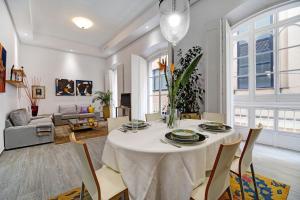 a dining room with a white table and chairs at Piso con Encanto in Cádiz