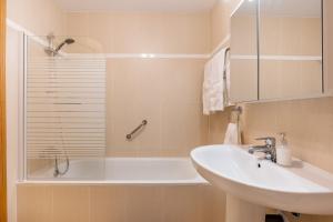 a bathroom with a sink and a shower and a tub at Apartamento Molinillo in Monachil +17 photos