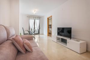 a living room with a couch and a flat screen tv at Apartamento Molinillo in Monachil