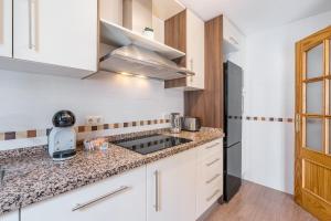a kitchen with white cabinets and a counter top at Apartamento Molinillo in Monachil