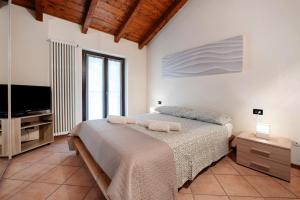 a bedroom with a bed and a flat screen tv at Miralago Marone Holiday House in Marone