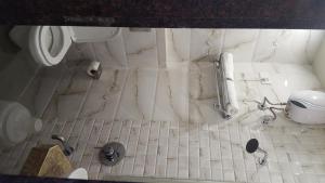 La salle de bains est pourvue de carrelage blanc. dans l'établissement Hotel Sanjary Palace, à Mumbai