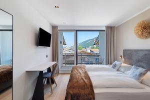 a bedroom with a bed and a desk and a window at Appartment Hofer Room Bergnest in Villabassa