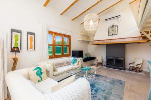 a living room with white furniture and a fireplace at Es Collet in Manacor
