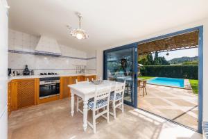 a kitchen and dining room with a table and a pool at Es Collet in Manacor