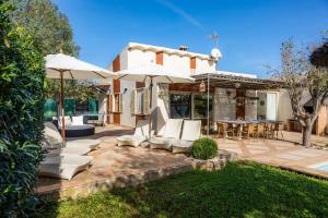 a patio with white chairs and umbrellas at Es Collet in Manacor