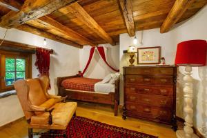 a bedroom with a bed and a chair and a dresser at Le Chalet du Coq Rouge in Valtournenche