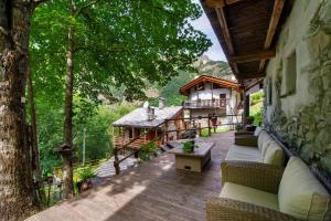 an outdoor patio with couches and a house at Le Chalet du Coq Rouge in Valtournenche