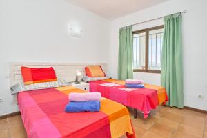 two beds with colorful sheets in a room at El Nido in Almuñécar +25 photos