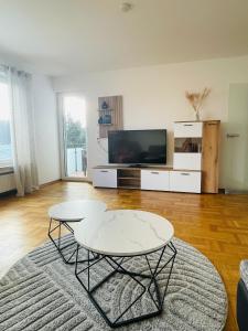 a living room with a table and a tv at Ferienwohnung Adelsried 2 in Adelsried