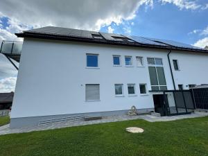 a white house with solar panels on it at Ferienwohnung Adelsried 2 in Adelsried