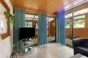 a living room with green curtains and a flat screen tv at Haus am See in Gedern