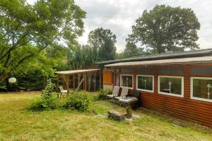 a small house with a bench and chairs in the yard at Haus am See in Gedern