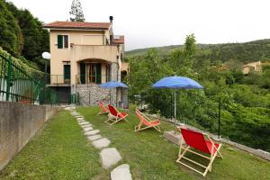 a group of chairs and umbrellas in a yard at Elena e Joerg 2 in Vezzi Portio