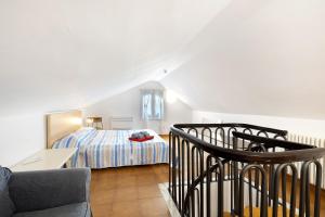 a bedroom with a bed and a couch in a room at Elena e Joerg 2 in Vezzi Portio