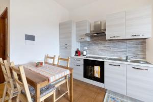 a kitchen with a table and a sink and a stove at Elena e Joerg 2 in Vezzi Portio +18 photos