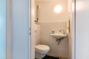 a small bathroom with a toilet and a sink at Appartment Piano in Deisenhofen +14 photos