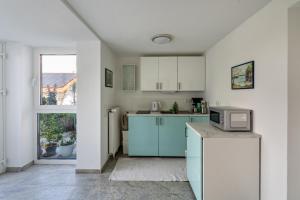 a kitchen with blue cabinets and a microwave at Appartment Piano in Deisenhofen