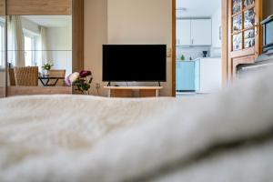 a bedroom with a bed and a flat screen tv at Appartment Piano in Deisenhofen