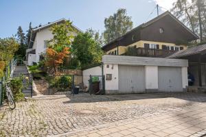 a house with a garage in front of a building at Appartment Piano in Deisenhofen