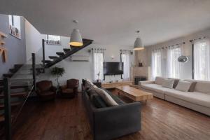a living room with a couch and a staircase at וילה levi in Chorazim