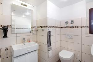 a white bathroom with a sink and a toilet at Nette Hütte in Bad Säckingen +15 photos