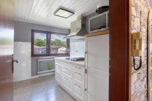 a kitchen with white cabinets and a window at Nette Hütte in Bad Säckingen