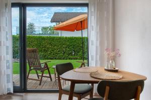 a dining room table with chairs and an umbrella at Meili's Haus in Uhldingen-Mühlhofen