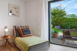 a bedroom with a bed and a large window at Meili's Haus in Uhldingen-Mühlhofen