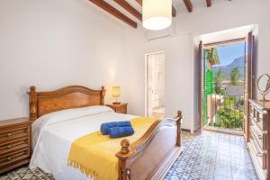 a bedroom with a bed and a large window at Casa Tramuntana in Sóller