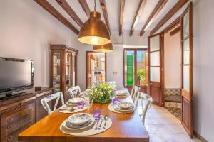 a dining room with a table and chairs and a television at Casa Tramuntana in Sóller