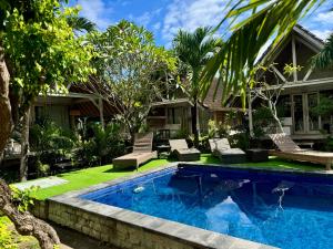 a swimming pool in front of a house at Danys House at Tiki Bar and More in Nusa Lembongan