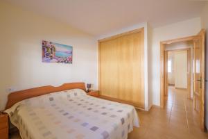 a bedroom with a bed and a sliding door at Playasol in Vinarós +13 photos