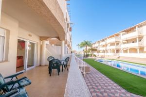 a balcony of a building with chairs and a swimming pool at Playasol in Vinarós