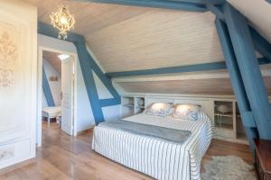 a bedroom with a bed with blue walls and wooden floors at Maison d'hôtes, Calme et Piscine in Habas