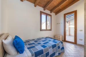 a bedroom with a blue and white bed and a window at Girasole 2 in Pula
