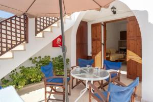 a table and chairs with an umbrella on the balcony of a house at Studios Asterias 2 in Astypalaia
