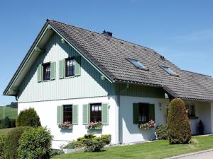 a white house with green shutters at Ferienwohnung Ketterer in Breitnau