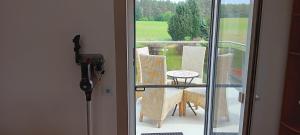 a glass door with a table and chairs on a balcony at Zur Schmiede in Hasselförde +7 photos