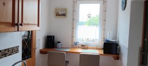 a kitchen with a counter with a window and chairs at Zur Schmiede in Hasselförde