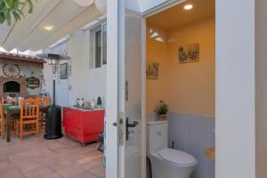 a bathroom with a toilet and a kitchen with a table at Loft Cerca Del Mar Tenerife in Punta del Hidalgo