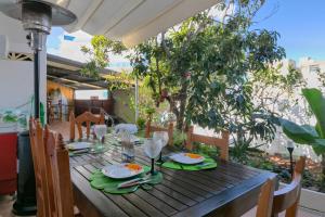 a wooden table with plates and wine glasses on it at Loft Cerca Del Mar Tenerife in Punta del Hidalgo