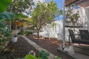 a backyard with a table and chairs and a tree at Loft Cerca Del Mar Tenerife in Punta del Hidalgo