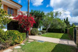 a house with a garden with red flowers at Can Toni in Pollença
