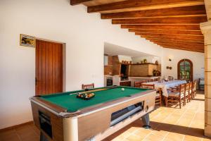 a living room with a pool table and a kitchen at Can Toni in Pollença