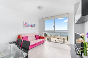 a living room with a pink couch and a view of the beach at Topete Alicante in Alicante