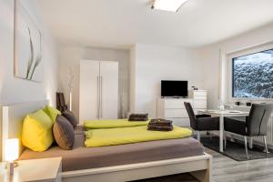 a bedroom with a yellow bed and a desk at Schwarzwaldblick K App 4 mit Pool in Schönwald