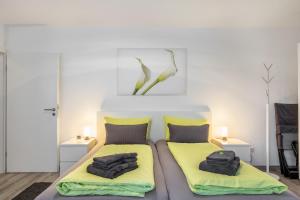 a bedroom with two beds with yellow cushions at Schwarzwaldblick K App 4 mit Pool in Schönwald +13 photos