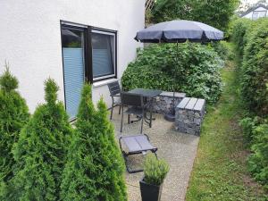 a patio with a table and an umbrella at Schwarzwaldblick K App 4 mit Pool in Schönwald